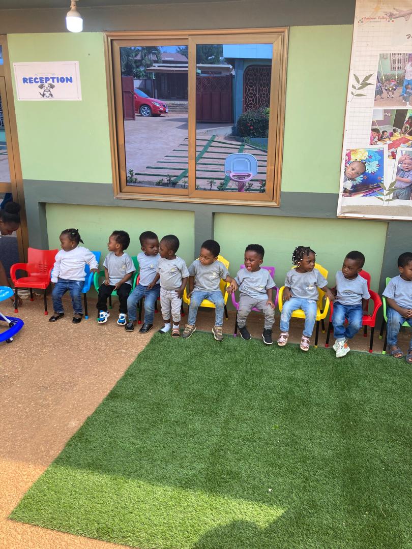 Children sitting together on the play grass at Sunshine Valley