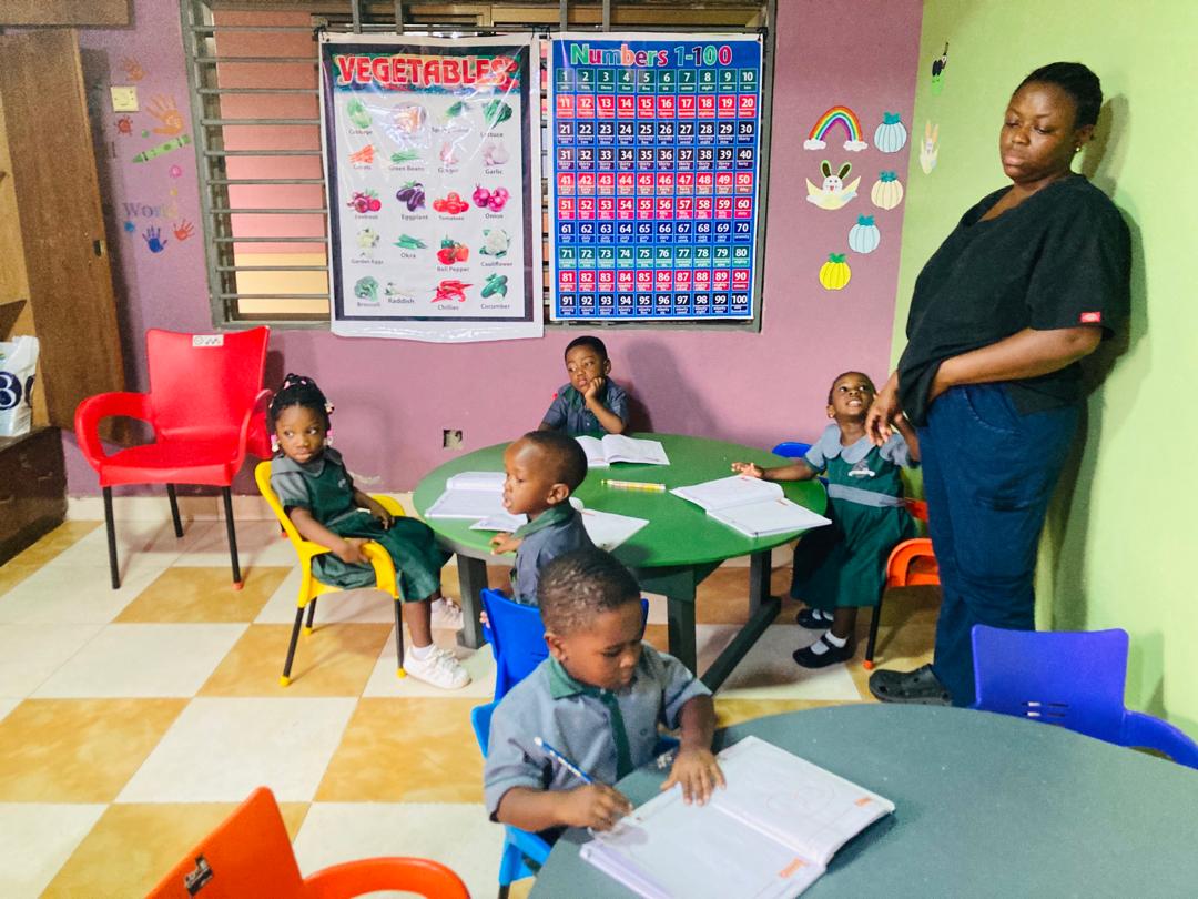 A teacher guiding children during a writing activity